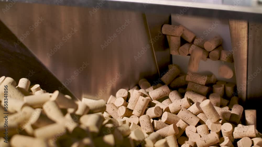 Poster many corks into a conveyor machine at a winery. static closeup shot.