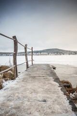 Snowy old bridge with snow and frozen lake