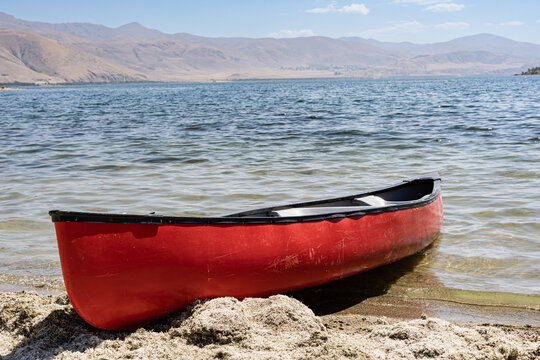 Red boat on a shore of lake Sevan in Armenia 