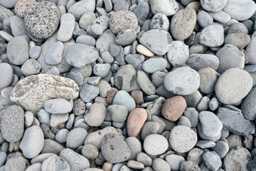 Rocky beach by the sea or ocean. Pebble background.