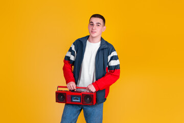 A handsome guy in the style of the 90s with a boombox on a yellow background