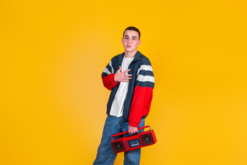 Naklejka premium A handsome guy in the style of the 90s with a boombox on a yellow background