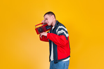A handsome guy in the style of the 90s with a boombox on a yellow background