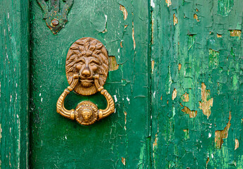 golden knokcer on green door