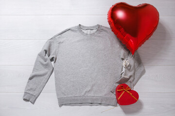 Grey sweatshirt mockup. Valentines Day concept shirt, balloon heart shape on wooden background....