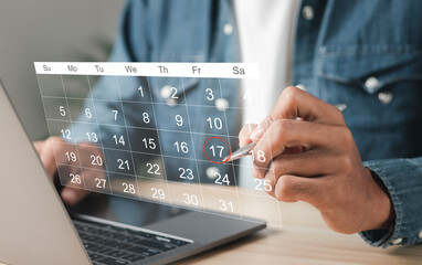 Businessman manages time for effective work. Calendar on the virtual screen interface. Highlight appointment reminders and meeting agenda on the calendar. Time management concept. - obrazy, fototapety, plakaty