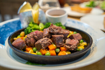 Beef Cubes Steak with mixed vegetables on a sizzler plate