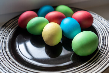 Multi color ester eggs on the dark plate. Close-up