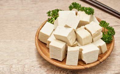 pile of white cube Tofu in wood plate on table kitchen background. fresh white cube tofu healthy food on kitchen background. heap of white cube tofu background                                    