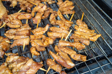 Grilling Thai sun-dried pork (Moo Dad Deaw) skewer for local street food vendor