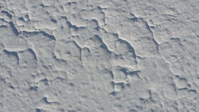 Aerial - Interesting wave pattern made on top of the soil by the snow in a forest field
