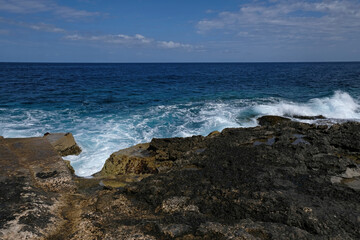 Blue sea wave and white foam. Stone beach on the island of Malta, no sandy beach. Summer holiday border frame concept. Tropical island vacation backdrop. Tourist travel banner design template.