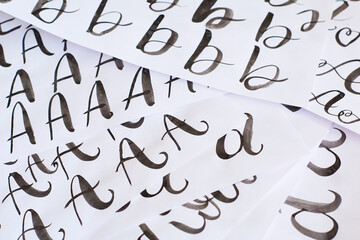 Several white sheets with calligraphic exercises. Calligraphy practice.