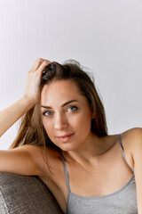 Obraz premium Portrait of beautiful woman with well-kept natural skin posing over grey studio background. Femininity
