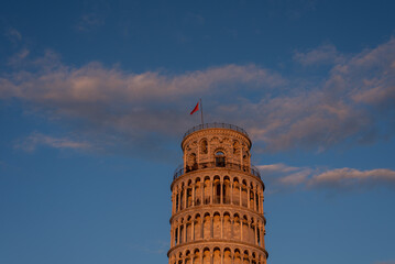 Low angle view of the Pisa tower against sunset blue cloudy sky.