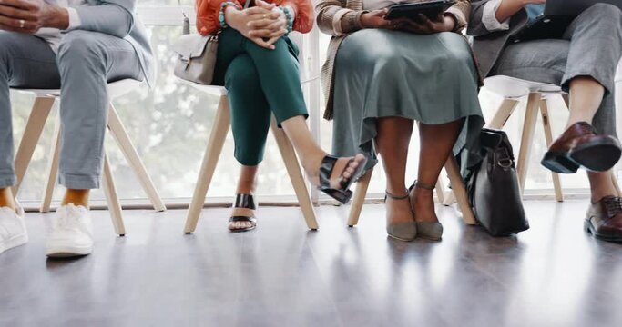 Interview, hiring and legs of business people waiting in a line in the lobby at a modern office. Recruitment, human resources and corporate candidates sitting in a row for a meeting in the workplace.