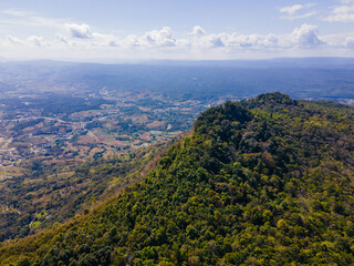 Fototapeta premium the aerial view of the mountain peak and the cliffs near the green forest