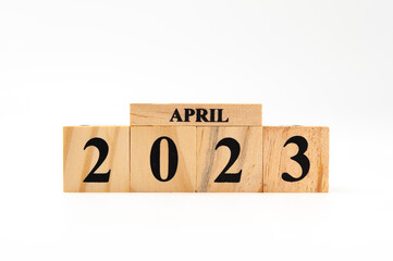 April 2023 written on wooden blocks isolated on white background with copy space