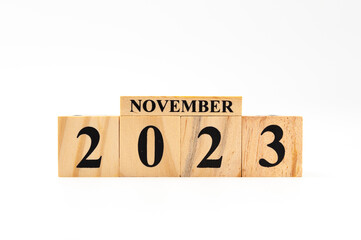 November 2023 written on wooden blocks isolated on white background with copy space