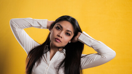 Naklejka premium Young pretty woman with Asian appearance posing for the camera - studio photography