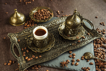 traditional turkish coffee in vintage cup in metal service, anise, roasted beans on brown background 2