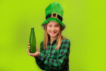 Happy smiling girl wearing green leprechaun hat and checkered plaid shirt, holding green beer bottle and looking at camera isolated on colorful green background.

Saint Patricks Day celebration.