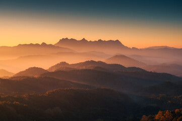Fototapeta na wymiar Scenery of sunrise over Doi Kham Fah mountain peak with foggy in tropical rainforest at national park, Chiang Dao, Chiang Mai