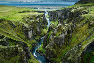 Stunning view of Fjadrargljufur canyon naturally eroded with Fjadra flowing through ravine in summer at Iceland