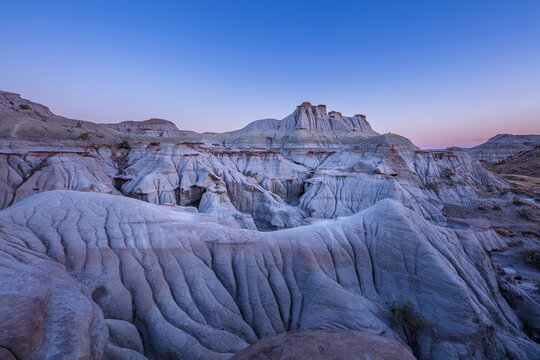 Barren badlands in the UNESCO World Heritage Site of Dinosaur Provincial Park in the blue hour before sunrise,  Alberta Canada