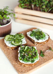 Three toasts on brown bread with home grown organic microgreens and cream cheese