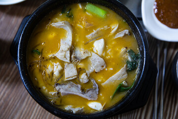 Boiled beef intestines, japchae, soybean paste, vegetables, and green onions in an earthen pot, Korean traditional food,