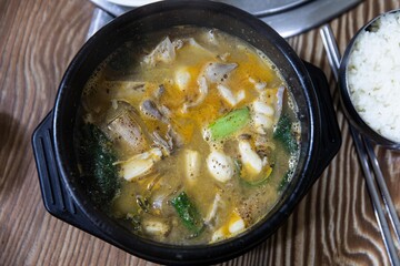 Boiled beef intestines, japchae, soybean paste, vegetables, and green onions in an earthen pot, Korean traditional food,