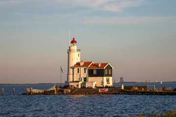 Fototapeta na wymiar paard van marken lighthouse on marken island in golden hour with blue sky and sea