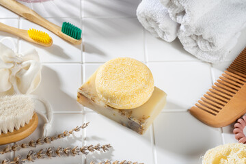 Sustainable solid shampoo bar and natural material bathroom accessories lying on a white background. Plastic free, zero waste, low water ingredients. Eco friendly hair care. life style composition