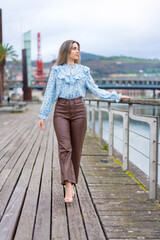 Young woman walking along the river in the city, lifestyle concept, enjoying the tranquility