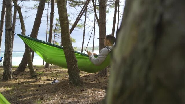 relaxing camsite holiday reading a book near trees and tents
