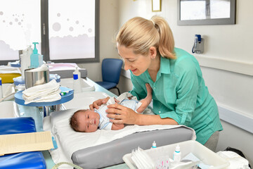 A nurse take cares of a newborn baby in the maternity hospital. First bath.