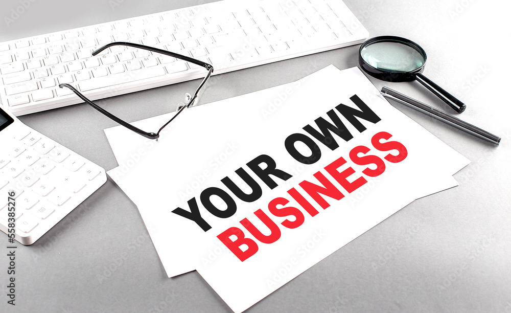 Poster your own business text on a paper with keyboard, calculator on grey background