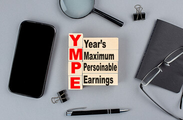 wooden cubes YMPE wtih notebook , magnifier and smartphone, business concept
