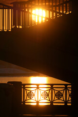 Silhouette of metal fences and handrails on the background of the sunset