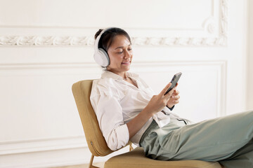 A woman listens to music on her mobile phone, sits and relaxes