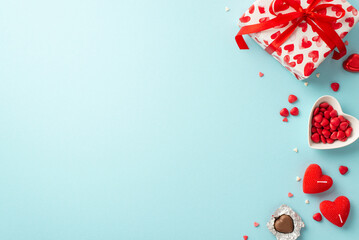 Valentine's Day concept. Top view photo of present box heart shaped saucer with sprinkles candies and candles on isolated light blue background with copyspace