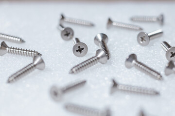 Tapping screws made of steel on table background, metal screw, iron screw, chrome screw, screws as a background, wood screw, concept industry. copy space for text.
