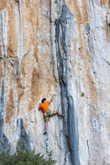 Extreme sport, man, rock climber climbs a difficult route.