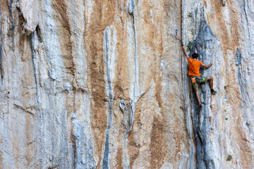 Fototapeta premium Extreme sport, man, rock climber climbs a difficult route.