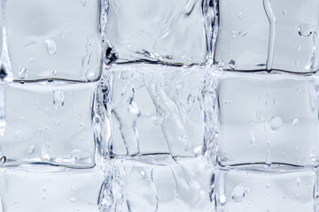 Water flows down over ice cubes on a white background