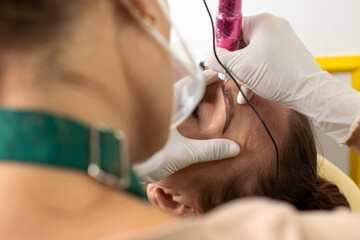 The process of permanent eyebrow makeup in a beauty salon. The permanent tattoo artist