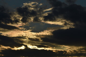 sun hiding behind clouds on cloudy evening day