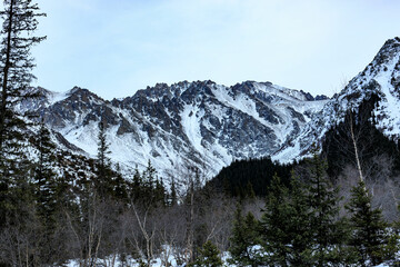 Snow-covered mountain, morning fog, mountain rocky ridges with pointed peaks, winter, sunny,...