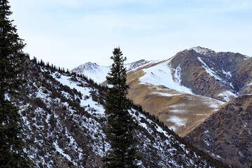Snow-covered mountain, morning fog, mountain rocky ridges with pointed peaks, winter, sunny,...
